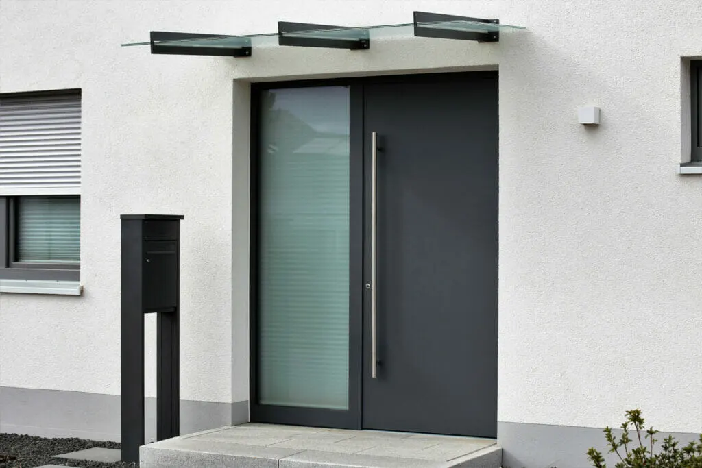 Von einem Gutachter geprüfte moderne Haustür mit Glashälfte und Vordach