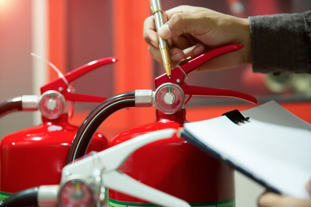 Brandschutzsachverstaendiger prueft Feuerloescher auf Tauglichkeit