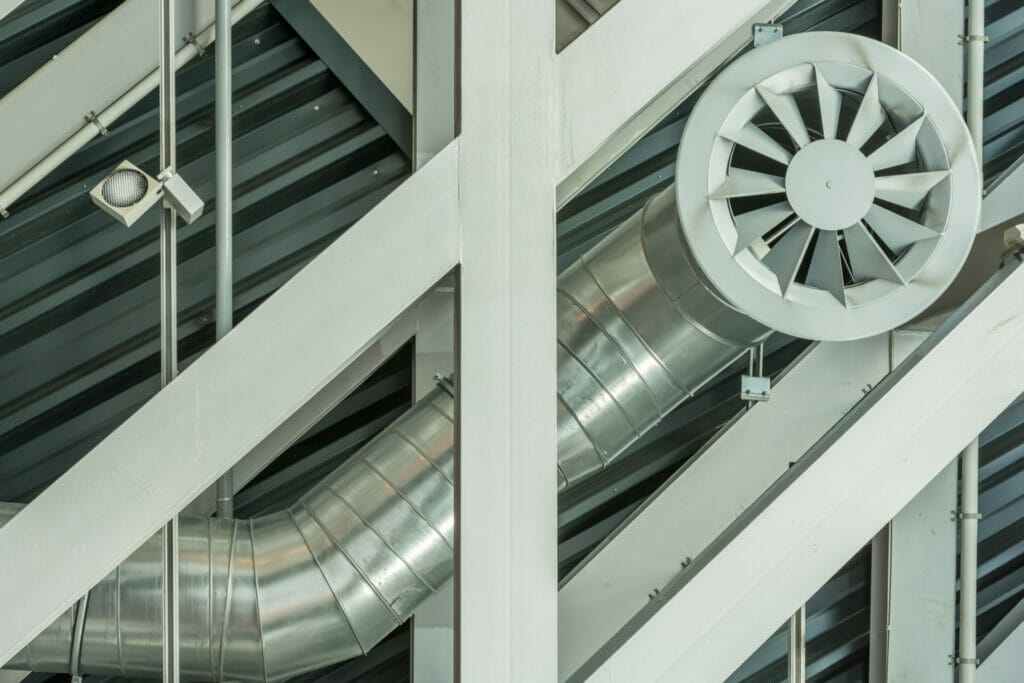 Lueftungsrohr mit Ventilator aus Aluminium an der Decke einer Halle